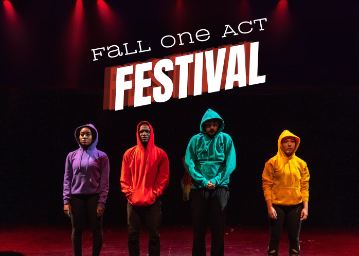 4 students in purple, red, teal and yellow hoodies standing in a black box theatre with