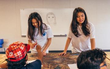 2 college seniors teaching a classroom of high schoolers
