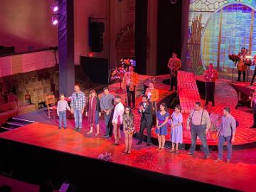 Director Karina Gutierrez joins her cast for the curtain call at Cruzar la Cara de la Lunas opening night image link to story