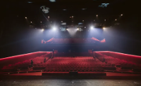 Looking from the stage to empty red velvet theatre seats