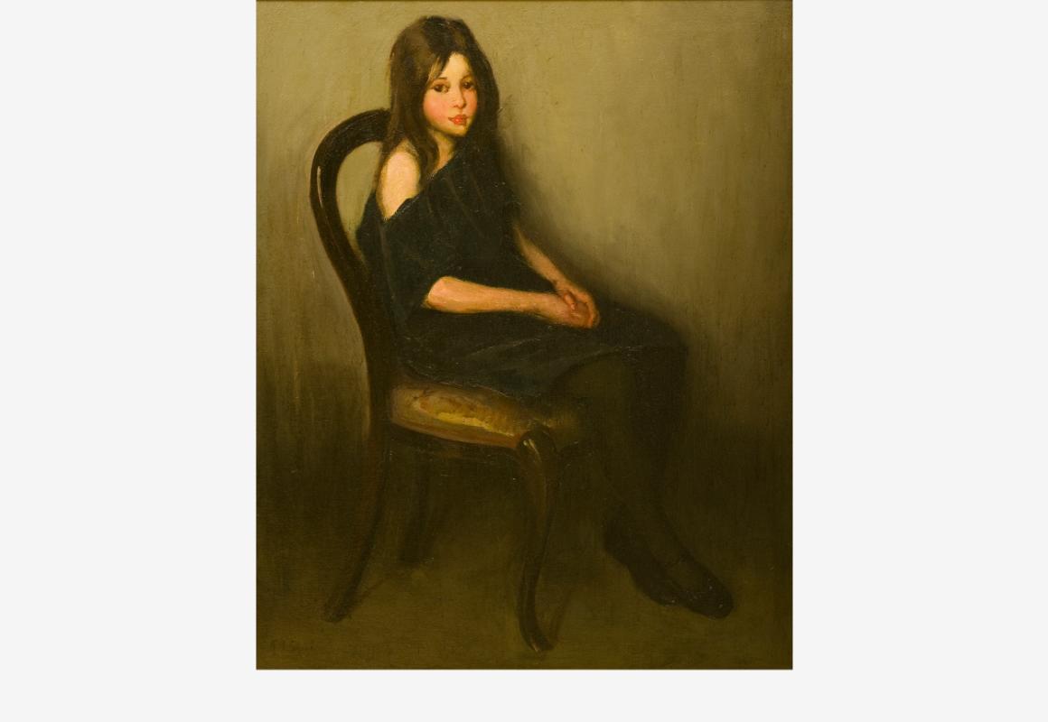Young girl sitting on a chair with a solemn expression on her face.