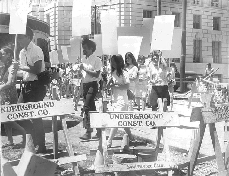 Black and white photograph of people marching in San Francisco with blank placard signs