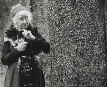 A person in dark clothing holding a small animal. 