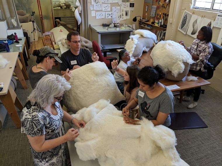 Group of people in artist studio working on artworks made of felt and wool