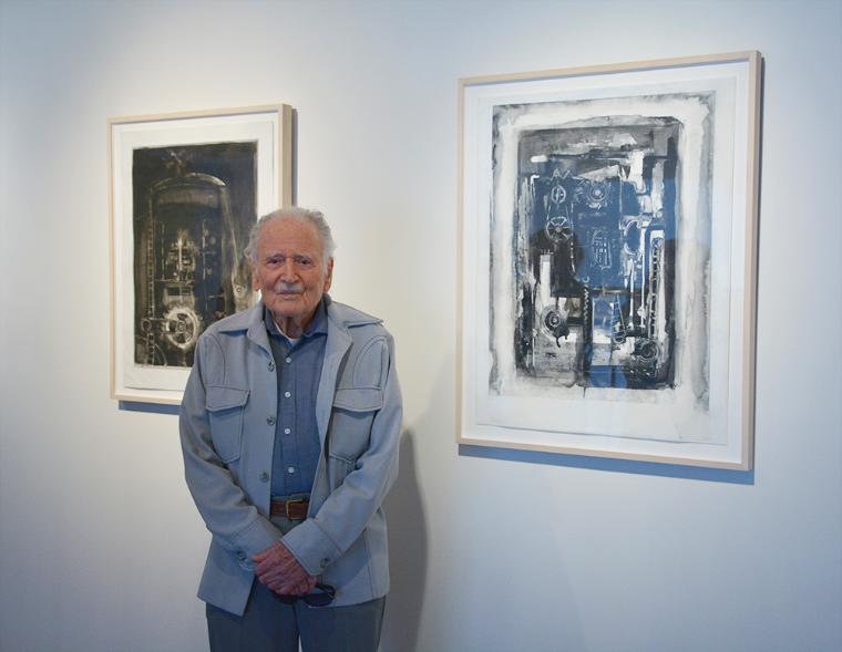 Artist Joseph Zirker standing with two of his artworks. image link to story