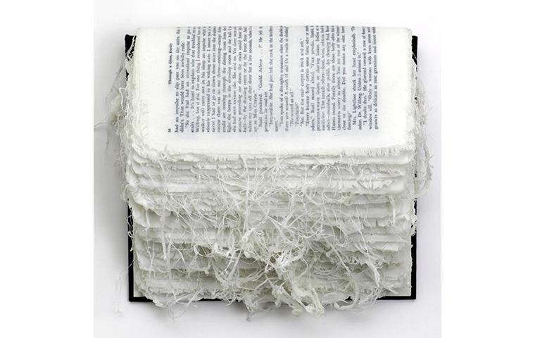 Wall sculpture created with linen printed to look like book pages that are unraveling