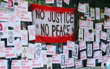 a wall with 'No Justice No Peace' signs and banners