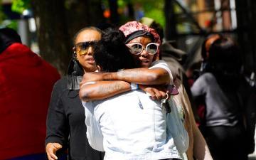 People waiting for news on the condition of friends and loved ones hug at the scene of a mass shooting In Sacramento, Calif. April 3, 2022.