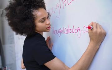 woman writing on a whiteboard