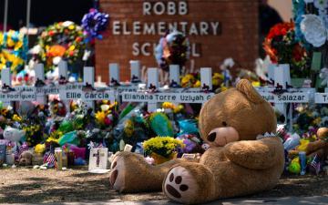 A large teddy bear is placed at a memorial in front of crosses bearing the names of the victims killed in this week's school shooting in Uvalde, Texas Saturday, May 28, 2022. (AP Photo/Jae C. Hong)