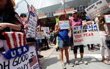 group of white protesters holding signs about essential jobs