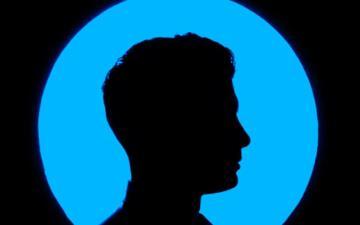 Profile picture silhouetted against a blue and black background