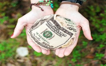 outreached hands with money