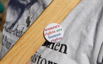 A person wearing a pin that says womens rights are human rights
