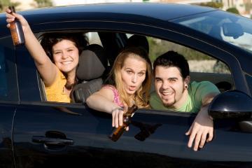 Students drinking beer in a car