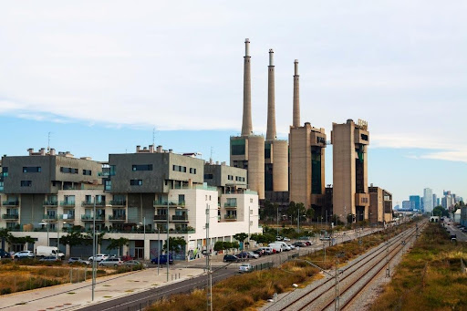 A residential zone in Barcelona is directly adjacent to a power station, with railroad tracks running parallel. Photo credit: www.freepik.com