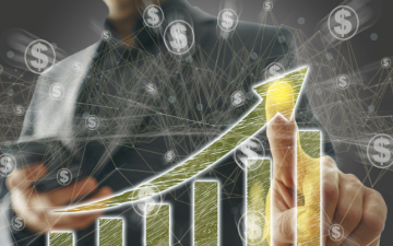 A person pointing at an upward-trending bar graph, representing growth.