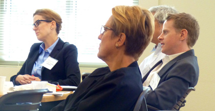 Four people attentively observing something in a professional setting.