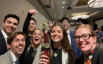 Fourth-place-winning 2022-23 Ethics Bowl team and advisor Dr. Erin Bradfield with their trophy.