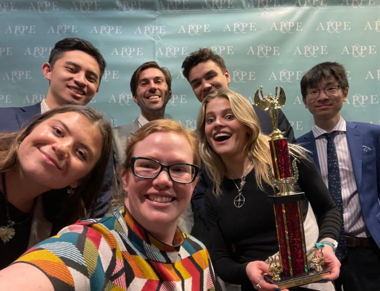 The 2022-23 Ethics Bowl team and advisor Dr. Erin Bradfield pose with their fourth-place trophy.