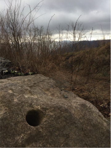 A leftover hole from dynamite, in a rock that was potentially launched from a nearby mining site, sits in Stanley Heirs Park. [6]