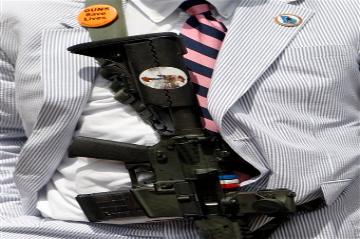 Man in a suit with a gun strapped to his chest. image link to story