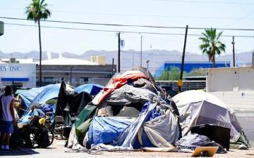 A cluster of tents and personal belongings situated roadside. Ross D. Franklin Associated Press