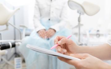 Young woman patient at gynecologist appointment consults with medical institution.