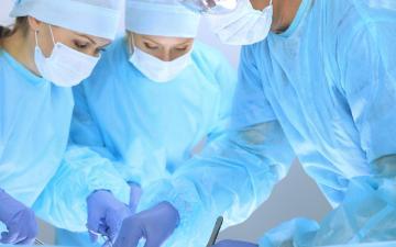 Medical team performing operation. Three of surgeons at work are busy of patient. Medicine, veterinary or healthcare and emergency in hospital By rogerphoto via Adobe Stock.
