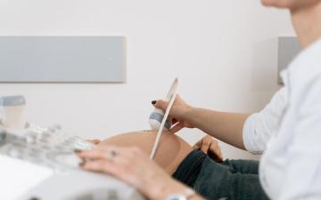 A healthcare professional examining ultrasound images on a tablet.