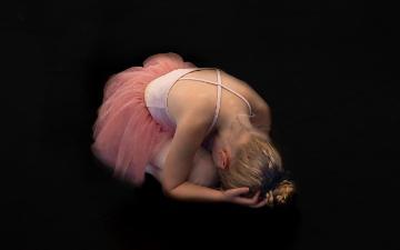 A young ballerina posed on floor with body curled into fetal position. Image by Rudy and Peter Skitterians from Pixabay.