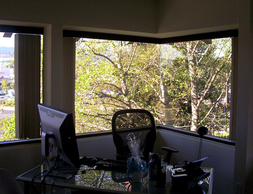 desk with computer in front of window