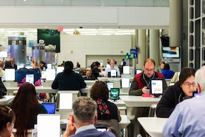 Image of journalists at their desks in a newsroom 