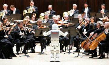 Hondas ASIMO robot conducts the Detroit Symphony Orchestra as it performs Impossible Dream (AP Images/Paul Sancya). image link to story