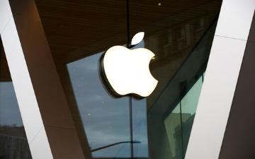 White Apple logo on a reflective glass surface. image link to story