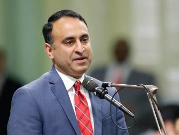 A person speaks into a microphone. image link to story