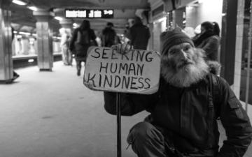 A person holding a sign saying HOMELESS need money for food COVID.