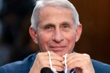 Dr. Anthony Fauci, Director of the National Institute of Allergy and Infectious Diseases, holds his face mask in his hands as he attends a House Committee on Appropriations subcommittee on Labor, Health and Human Services, Education, and Related Agencies hearing, about the budget request for the National Institutes of Health, Wednesday, May 11, 2022, on Capitol Hill in Washington. Jacquelyn Martin