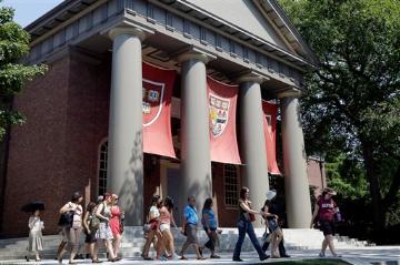 People walking in front of a building with prominent columns at Harvard University. image link to story