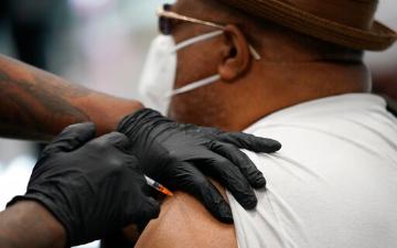 Person receiving a vaccine injection in the upper arm. image link to story