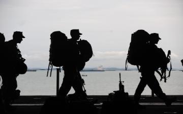 Service members carrying duffle bags and equipment image link to story