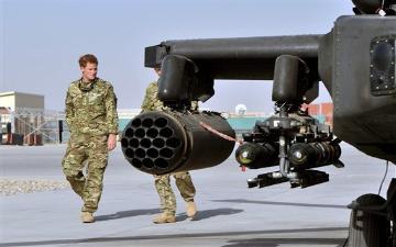 Britain's Prince Harry, left, is shown the Apache helicopter by a member of his squadron (name not provided) at Camp Bastion in Afghanistan, Friday Sept. 7, 2012. Prince Harry will be based at Camp Bastion during his tour of duty as a co-pilot gunner, returning to Afghanistan to fly attack helicopters in the fight against the Taliban. (AP Photo/John Stillwell) image link to story