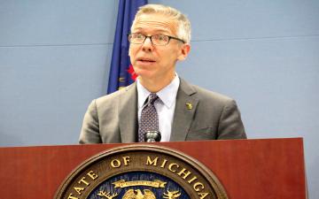 A man speaking at a podium with an official seal. image link to story