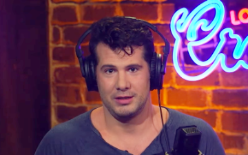 Person speaking into a microphone, with the illuminated text Crowder in the background. image link to story