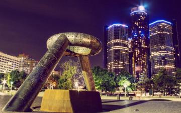 Monument of a fist in front of lit skyscrapers in Detroit at night. image link to story