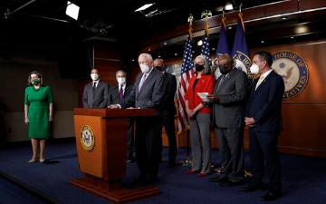 Group of officials speaking at a podium with USA flag backdrop. image link to story