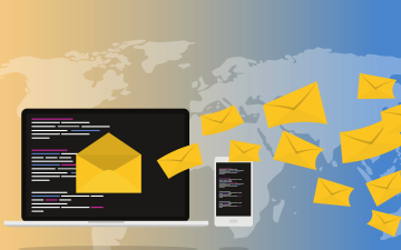 A laptop and smartphone with emails flying over a world map. image link to story