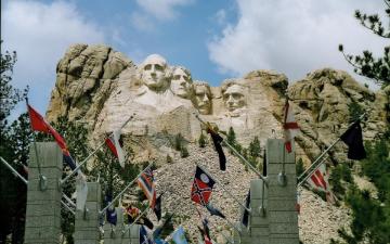 The image shows Mount Rushmore with sculptures of four U.S. presidents and a pathway in the foreground. image link to story