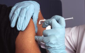Person receiving a vaccine injection in the arm. image link to story