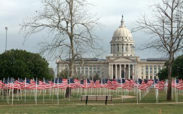 Oklahoma State Capitol with numerous small American flags on the lawn. image link to story